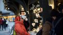 Warga memakai masker untuk melindungi diri dari virus corona saat mengunjungi pasar Natal di Wina, Austria, Rabu (17/11/2021). Warga yang tak divaksin dilarang untuk beraktivitas di Pasar Natal untuk mencegah penularan virus corona. (AP Photo/Michael Gruber)