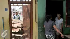 Warga bukit Duri berbincang di rumah yang sebagian telah dibongkar oleh Pemprov DKI Jakarta, Selasa (13/9). Pemprov DKI berencana keluarkan Surat Peringatan (SP) 3 hari ini yang dilanjutkan pembongkaran pada Rabu 14/9 besok. (Liputan6.com/Yoppy Renato)