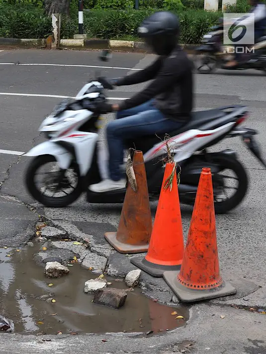Pengendara menghindari jalan berlubang di kawasan Tanjung Barat, Jakarta, Rabu (30/1). Kondisi jalan rusak tersebut telah beberapa kali menyebabkan kecelakaan sehingga butuh penanganan. (Liputan6.com/Immanuel Antonius)