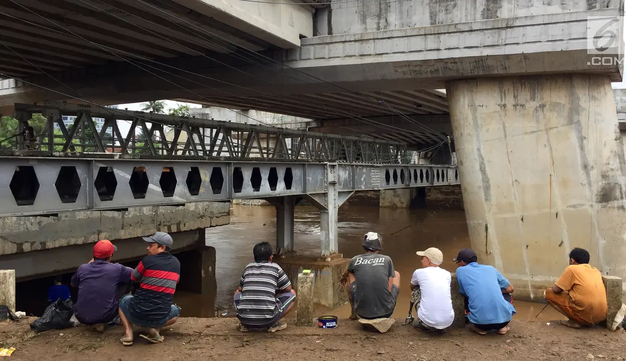 Warga berkumpul untuk memancing ikan dari Sungai Ciliwung yang meluap di Rawajati,Jakarta, Selasa (6/2). Banyak ikan yang hanyut terbawa arus banjir Sungai Ciliwung. (Liputan6.com/Immanuel Antonius)