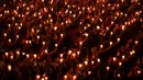 Umat Kristen memegang lilin saat ibadah malam Natal di Gereja Bethany, Surabaya, Jawa Timur, Minggu (24/12/2023). Pelaksanaan ibadah malam Natal berjalan aman dan lancar. (Juni KRISWANTO/AFP)