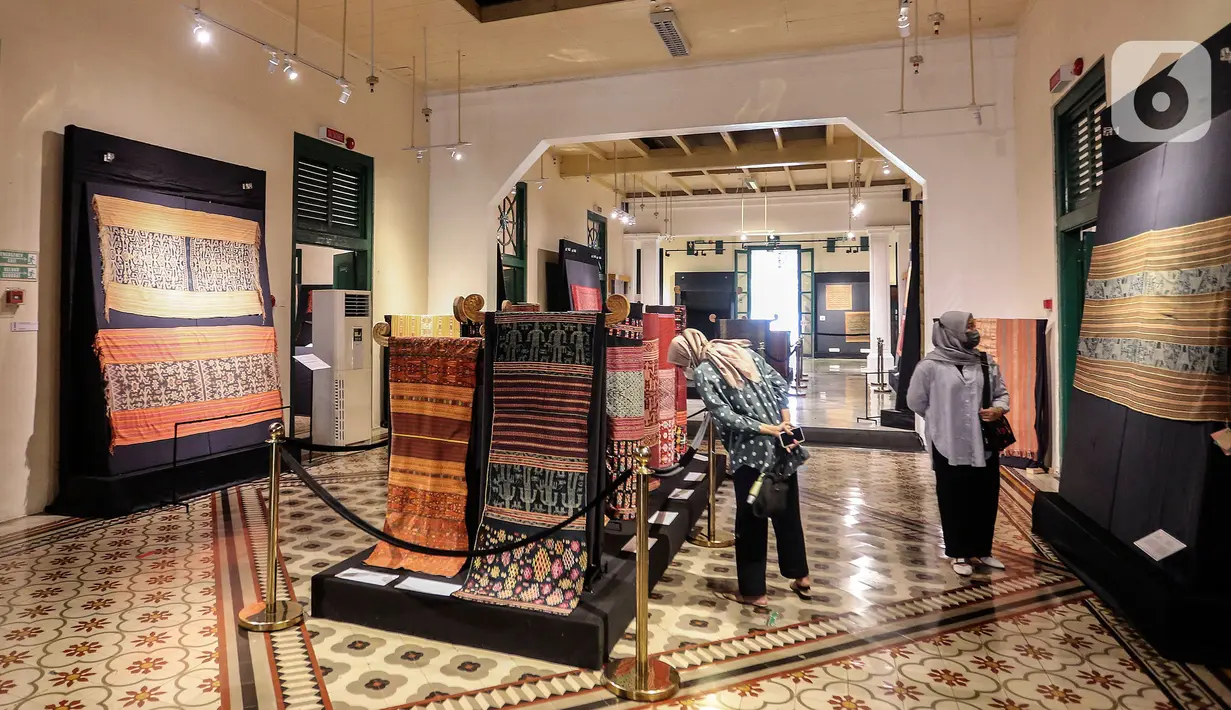 Pengunjung melihat kain tenun di pameran tenun bertajuk "Nuansa Kemilau Wastra Tenun Indonesia" di Museum Tekstil, Jakarta, Rabu (20/7/2022). Pameran dalam rangka memperingati HUT ke - 77 RI ini berlangsung hingga 31 agustus 2022 mendatang dan menampilkan kerajinan tenun dari Sumatera, Sulawesi, dan Timor. (Liputan6.com/Johan Tallo)