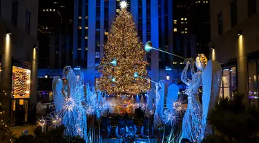 Lebih dari 50.000 lampu menghiasi Pohon Natal Rockefeller Center setinggi 75 kaki pada upacara tahunan pencahayaan di New York, Rabu (2/11/2020). Upacara yang digelar pada masa pandemi COVID-19 ini mewajibkan pengunjung untuk memakai masker, pembatasan waktu, dan jaga jarak. (AP Photo/Craig Ruttle)