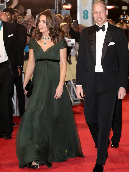 Kate Middleton didampingi Pangeran William berjalan di karpet merah acara penghargaan film British Academy Film Awards (BAFTA) 2018 di London, Minggu (18/2). Kate mengenakan dress panjang berwarna hijau lumut karangan Jenny Packham. (AP/Antonio Calanni)
