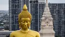 Patung Buddha raksasa setinggi 69 meter berdiri di kuil Wat Paknam Phasi Charoen di pinggiran Bangkok, Thailand pada Selasa (12/10/2021). Kuil Wat Paknam Phasi Charoen yang dibangun pada 1610 memutuskan untuk membangun patung untuk menghormati agama Buddha. (Jack TAYLOR / AFP)