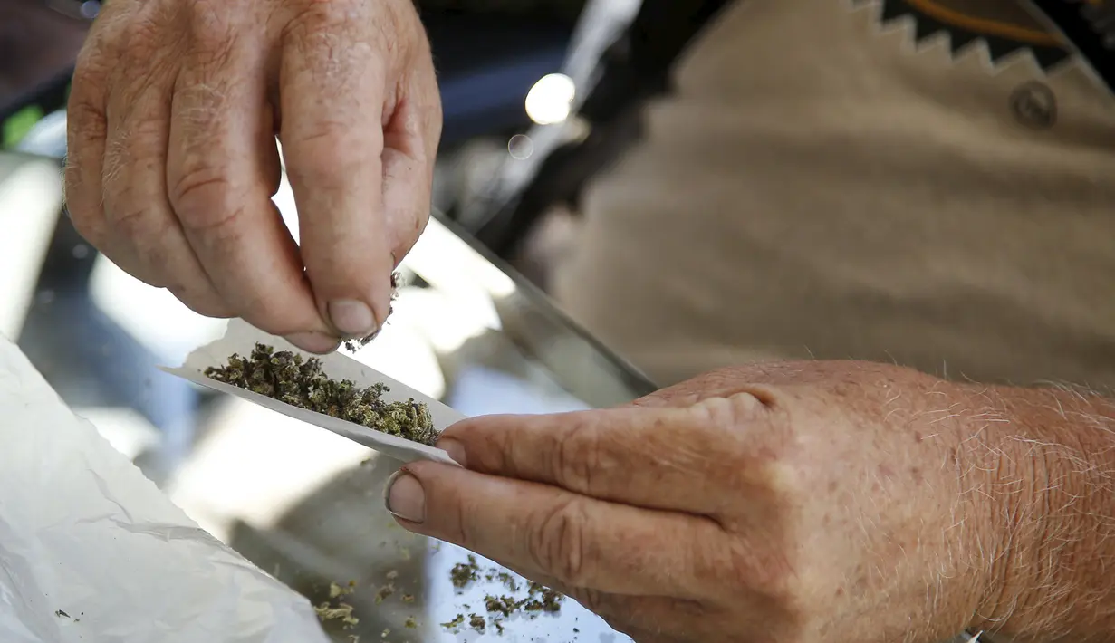 Warga membuat ganja kering di dalam kertas saat acara 'Weed the People' merayakan legalisasi penggunaan ganja di Portland, Oregon (3/7/2015). Pemerintah Oregon telah melegalkan penggunaan ganja Pada 1 Juli lalu. (REUTERS/Steve DiPaola)