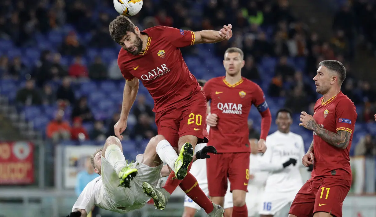Pemain AS Roma Federico Fazio (tengah) berebut bola dengan pemain Gent Roman Bezus pada leg pertama babak 32 besar Liga Europa di Olympic Stadium, Roma, Italia, Kamis (20/2/2020). Gol tunggal Carles Peres membawa AS Roma menaklukkan Gent 1-0. (AP Photo/Gregorio Borgia)