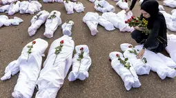 Sejumlah kantong mayat palsu yang dimaksudkan untuk mewakili korban tewas diletakkan di trotoar di luar halaman utara Gedung Putih. (AP Photo/Andrew Harnik)