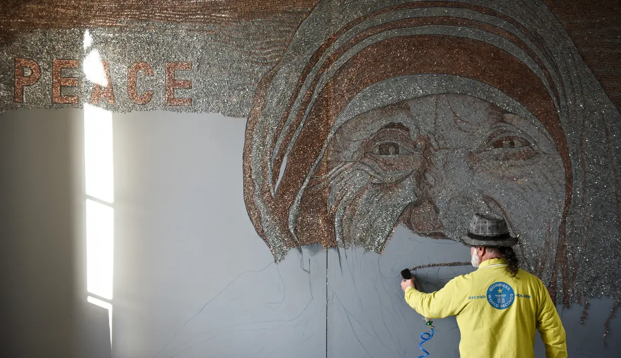 Seniman asal Albania, Saimir Strati saat membuat karya mosaik wajah Suster Teresa menggunakan staples di Museum Pristina, Kosovo (16/11).  Saimir Strati adalah salah satu seniman mosaik yang terkenal di dunia. (AFP/Armend Nimani)
