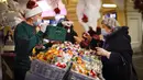 Seorang wanita yang mengenakan masker untuk membantu mengekang penyebaran virus corona COVID-19 melihat dekorasi Natal di GUM State Department Store, Moskow, Rusia, Senin (23/11/2020). Rusia saat ini memiliki jumlah kasus COVID-19 terbesar kelima di dunia. (AP Photo/Alexander Zemlianichenko)