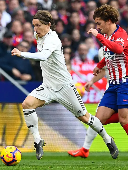 Striker Atletico Madrid, Antoine Griezmann berusaha merebut bola yang dibawa gelandang Real Madrid, Luka Modric selama pertandingan Liga Spanyol di di stadion Wanda Metropolitano di Madrid (9/2/2019). (AFP Photo/Gabriel Bouys)