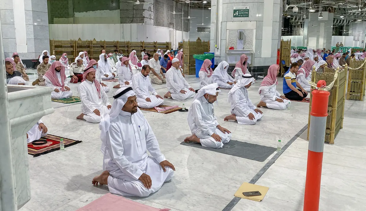 Umat Muslim melaksanakan salat tarawih berjemaah dengan menjaga jarak selama bulan suci Ramadan di Masjidil Haram, Kota Mekkah pada 8 Mei 2020. Otoritas Saudi mengizinkan sejumlah jemaah  memasuki Masjidil Haram untuk melakukan salat selama Ramadan di tengah pandemi virus corona. (STR / AFP)