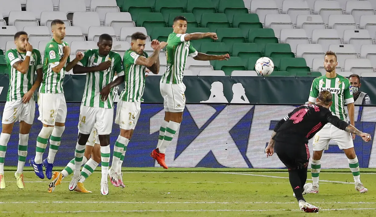 Pemain Real Madrid Sergio Ramos melakukan tendangan bebas saat menghadapi Real Betis pada pertandingan La Liga di Stadion Benito Villamarin, Seville, Spanyol, Sabtu (26/9/2020). Real Madrid mengalahkan Real Betis 3-2. (AP Photo/Angel Fernandez)
