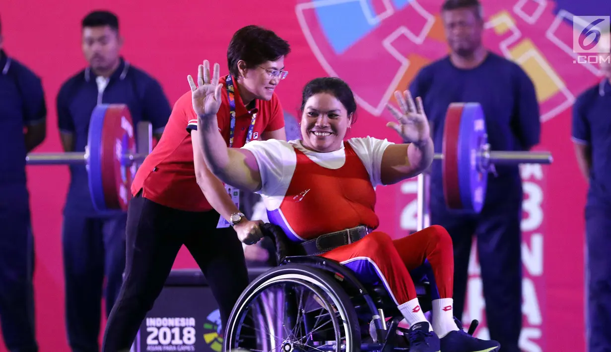 Atlet Para Powerlifting Indonesia, Nurtani Purba melambaikan tangan usai mengangkat beban di kelas Womens Up 73kg Asian Para Games 2018 di Jakarta, Rabu (10/10). Nurtani Purba meraih perak dengan total angkatan 1115 kg. (Liputan6.com/Helmi Fithriansyah)