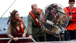 Kate Middleton dan Pangeran William terlihat senang saat mendapatkan kepiting besar saat memancing bersama di Haida Gwaii, Kanada, (30/9). (REUTERS/Chris Wattie)