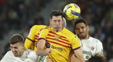 Penyerang Barcelona,  Robert Lewandowski (tengah) menyundul bola saat bertanding melawan Elche pada pertandingan lanjutan La Liga Spanyol di Stadion Martinez Valero di Elche, Spanyol, Sabtu,Minggu, 2 April 2023. (AP Photo/Alberto Saiz)