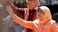 Halimah Yacob melambaikan tangan ke pendukungnya saat tiba untuk menyerahkan berkas pencalonan presiden di Singapura, Rabu (13/9). Halimah telah malang melintang di perpolitikan Singapura, serta menjadi ketua parlemen sejak 2013. (AP Photo/Wong Maye-E)