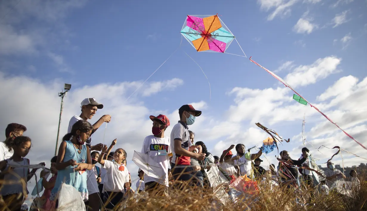 Anak-anak menerbangkan layang-layang dalam acara peringatan 400 tahun permukiman kumuh Petare di Caracas, Venezuela (17/2/2021). Kota ini didirikan pada 1621 dengan nama San Jose de Guanarito. (AP Photo/Ariana Cubillos)