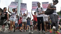 Komunitas pecinta anjing membawa aneka poster saat aksi di Bundaran HI, Jakarta, Minggu (13/12/2015). Mereka meminta semua pihak untuk tidak memakan daging anjing karena anjing adalah sahabat bukan makanan. (Liputan6.com/Johan Tallo)