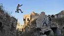 Sejumlah pemuda berlatih parkour di Aleppo, Suriah, (7/4). Setelah pemerintah Suriah mengambil alih kendali penuh Aleppo dari pasukan pemberontak Desember 2016, beberapa pemuda kini menyalurkan hobinya, yaitu parkour.  (AFP Photo/George Ourfalian)