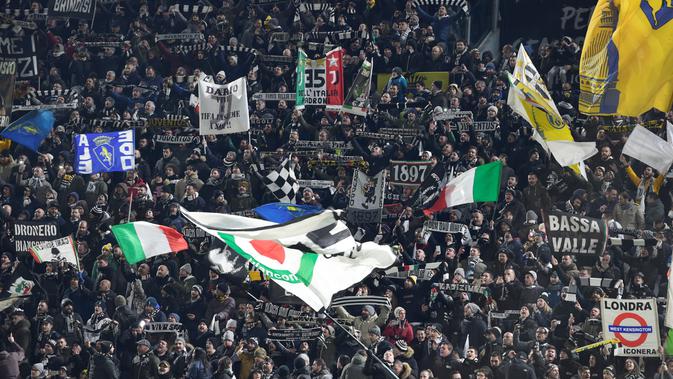Aksi suporter Juventus mengibarkan bendera saat mendukung timnya melawan Tottenham pada laga 16 besar Liga Champions di The Allianz Stadium, Turin, (13/2/2018). Juventus bermain imbang 2-2 dengan Tottenham.  (AFP/Migul Medina)