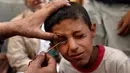 Seorang saat kelopak matanya dirias dengan kohl atau celak di  Masjid Agun di kota tua ibukota Sanaa, Yama, (19/5). Pemakaian kohl atau celak diyakini muslim Yaman mampu membersihkan dan melindungi mata dari penyakit. (AFP Photo/Mohammed Huvais)