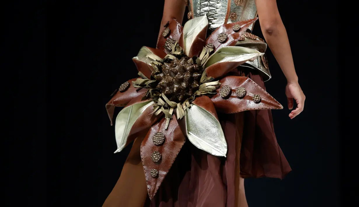 Detail gaun yang dibuat dari bahan cokelat saat dikenakan seorang model dalam sebuah pameran yang dikombinasikan dengan fashion show di Paris, 27 Oktober 2017. Pameran tersebut bertajuk Salon Du Chocolat. (AP Photo/Thibault Camus)