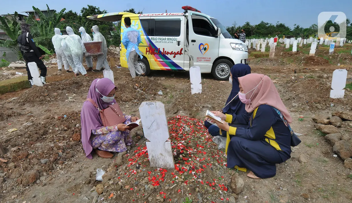 Warga berziarah dengan latar belakang pemakaman korban Covid-19 di TPU Srengseng Sawah 2, Jagakarsa, Jakarta, Senin (17/5/2021). Hari ini seluruh TPU di wilayah DKI dibuka untuk umum dengan menerapkan protokol kesehatan seperti pembatasan pengunjung dan waktu berziarah. (merdeka.com/Arie Basuki)