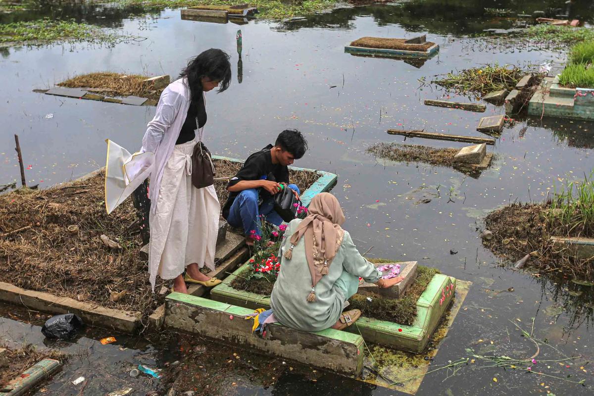 FOTO: Perjuangan Warga Berziarah di Tengah Banjir TPU Semper