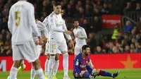 Striker Barcelona, Lionel Messi, terduduk lesu saat laga melawan Real Madrid pada laga La Liga 2019 di Stadion Camp Nou, Rabu (18/12). Kedua tim bermain imbang 0-0. (AP/Emilio Morenatti)