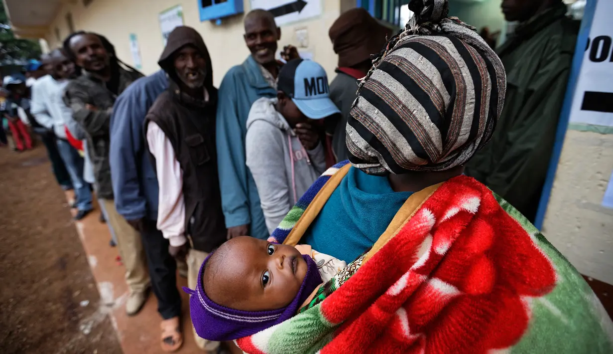 Wanita Kenya menggendong anaknya sambil mengantre untuk menggunakan hak pilih di Gatundu, utara Nairobi, Selasa (8/8). Negara berpenduduk 50 juta jiwa itu akan memilih presiden baru antara Uhuru Kenyatta dan pesaingnya, Raila Odinga (AP Photo/ Ben Curtis)
