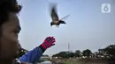 Toni membunyikan peluit saat melatih burung free fly di Jakarta, Minggu (26/7/2020). Berbeda dengan burung kicau, free fly merupakan hobi memelihara burung kecil tidak dalam sangkar alias dapat terbang bebas namun tidak akan kabur meninggalkan tuannya. (merdeka.com/Iqbal Nugroho)