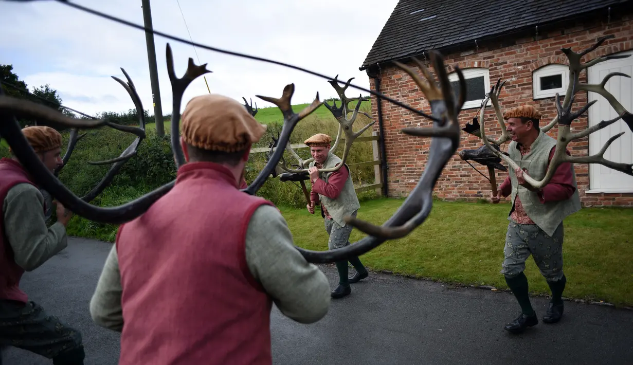 Para penari melakukan 'Abbots Bromley Horn Dance' di desa Abbots Bromley, Inggris (11/9). Tarian ini dibawakan oleh enam orang dengan menggunakan tanduk rusa kutub yang berasal dari abad ke-11 atau sudah berusia 1000 tahun. (AFP Photo/Oli Scarff)