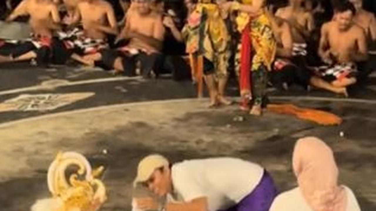 Alih-alih menari bersama, si penari kostum hanoman ini tampak memberikan suatu benda kepada pria tersebut.