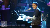 Penyanyi Glenn Fredly memainkan piano saat Konser Tanda Mata Glenn Fredly Untuk Ruth Sahanaya di kawasan Semanggi, Jakarta, Jumat (30/9). Konser ini dipersembahkan untuk 30 tahun Ruth Sahanaya berkarya. (Liputan6.com/Herman Zakharia)