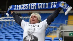 Seorang fans memakai baju bergambar Vichai Srivaddhanaprabha saat Leicester melawan Cardiff pada laga Premier League di Stadion Cardiff City, Wales, Sabtu (3/11). Pemilik Leicester meninggal akibat kecelakaan helikopter. (AFP/Oli Scarff)