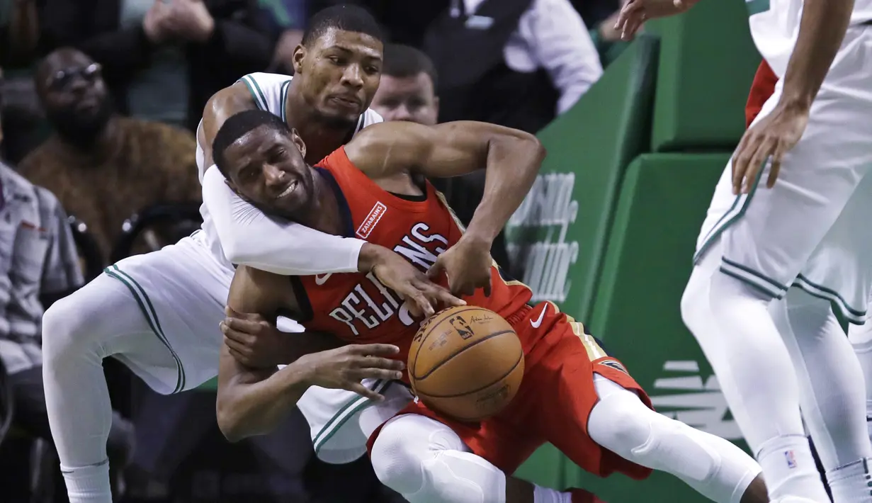 Aksi pemain Boston Celtics, Marcus Smart (kiri) berebut bola dengan pemain New Orleans Pelicans, Ian Clark (2) pada laga NBA basketball game di TD Garden, Boston, (16/1/2018). Celtics kalah 113-116. (AP/Charles Krupa)