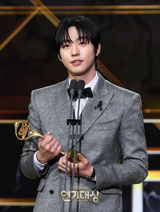 Ahn Hyo Seop tampil gagah dengan setelan jas dan celana panjang abu-abu. Penampilannya semakin gentleman dengan kemeja putih dan dasi kupu-kupu hitam. [Foto: Instagram/sbsdrama.official]