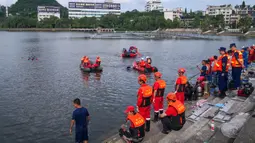 Tim penyelamat mencari korban selamat dari sebuah bus yang jatuh ke danau di Anshun, provinsi Guizhou, China, Selasa (7/7/2020). Sedikitnya 21 orang tewas usai bus yang membawa siswa untuk mengikuti ujian masuk perguruan tinggi atau gaokao itu menabrak pagar pembatas lalu tercebur ke danau (STR/AFP)