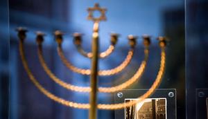 Sebuah foto yang menunjukkan menorah Hanukkah milik keluarga Posner dari Kiel dengan bendera swastika besar tergantung dari fasad bangunan di seberangnya dipamerkan dalam pameran barang-barang peringatan Holocaust di Parlemen Jerman Bundestag, Berlin, Jerman, 23 Januari 2023. Pameran untuk memperingati 70 tahun Yad Vashem, peringatan resmi Israel untuk orang-orang Yahudi korban Holocaust sejak 1953, menghadirkan berbagai benda sehari-hari yang dibawa oleh orang Yahudi ketika mereka melarikan diri dari Nazi. (AP Photo/Markus Schreiber)
