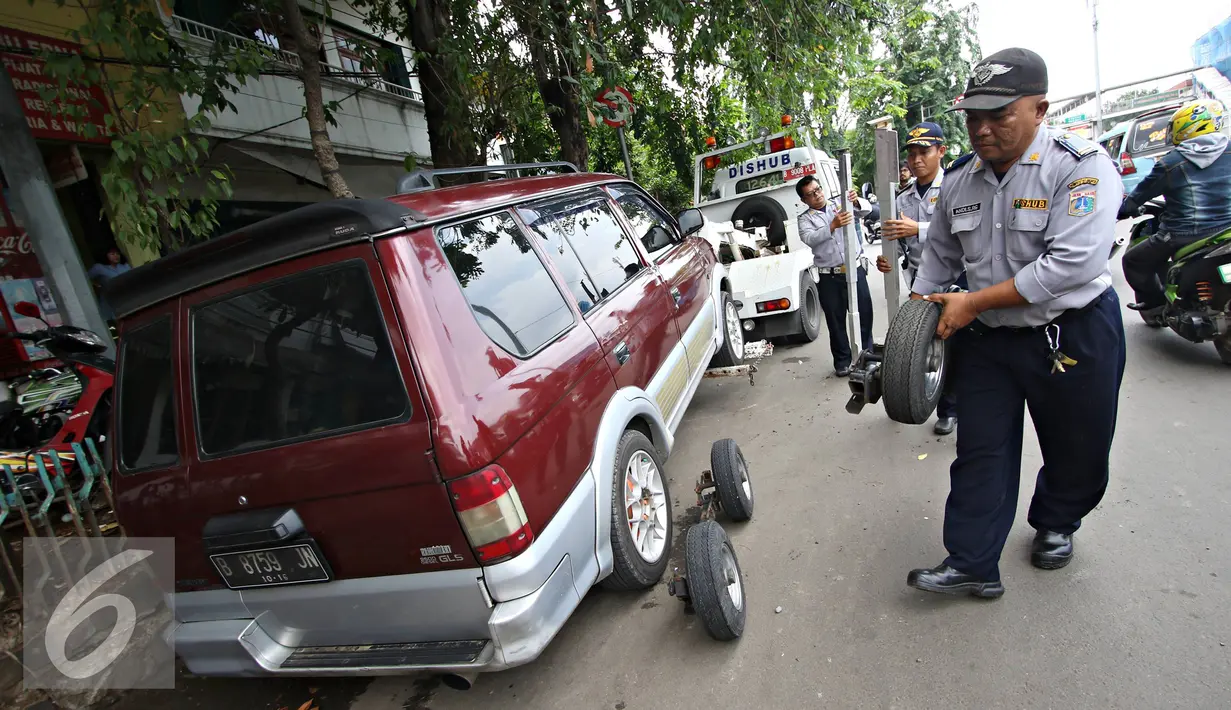 Petugas Dinas Perhubungan DKI Jakarta melakukan razia parkir liar di kawasan Jatinegara, Jakarta, Senin (28/12). Meski sudah ditertibkan, pengendara masih tak menghiraukan peraturan tersebut. (Liputan6.com/Immanuel Antonius)