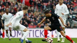 Striker Kroasia, Andrej Kramaric, berusaha melewati bek Inggris, John Stones, pada laga UEFA Nations League di Stadion Wembley, London, Minggu (18/11). Inggris menang 2-1 atas Kroasia. (AFP/Adrian Dennis)