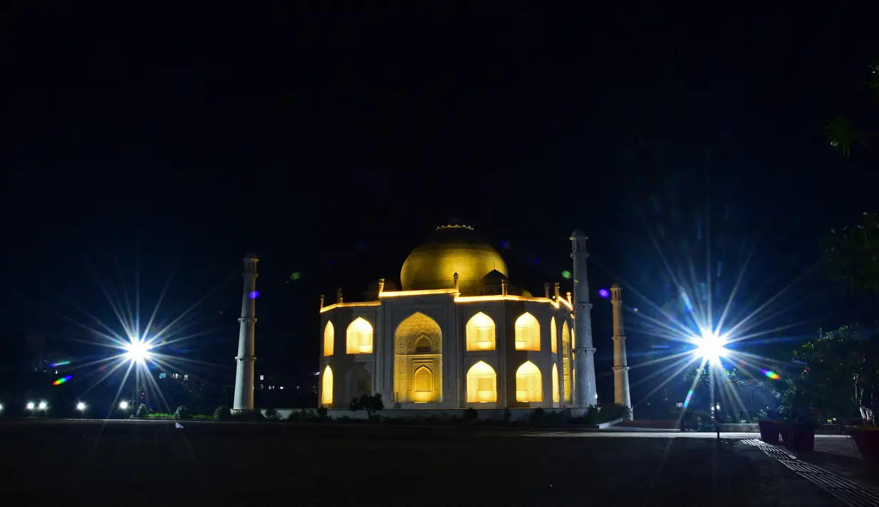 Dalam foto yang diambil pada 25 November 2021 ini, sebuah replika Taj Mahal yang diterangi tampak di Burhanpur di negara bagian Madhya Pradesh, India. Pengusaha India Anand Prakash Chouksey membangun replika Taj Mahal untuk istrinya. (Uma Shankar MISHRA / AFP)