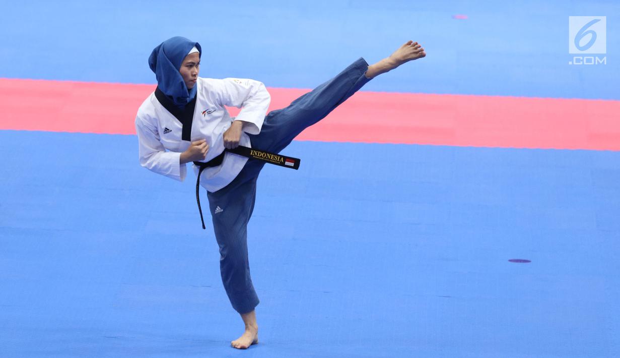 Atlet Taekwondo putri Indonesia, Defia Rosmaniar saat beraksi melawan Salahshouri Marjan (Iran) pada Final Women Individual Poomsae di JCC, Jakarta, Minggu (19/8). Defia Rosmaniar berhasil meraih emas. (Liputan6.com/Helmi Fithriansyah)