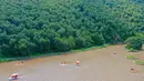 Foto yang diabadikan pada 16 Agustus 2020 ini menunjukkan wisatawan yang menikmati perjalanan dengan perahu di kawasan wisata Jiulongwan di Wilayah Zhuozi, Ulanqab, Daerah Otonom Mongolia Dalam, China utara. (Xinhua/Peng Yuan