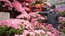 Seorang pedagang menjual azalea di pasar bunga di area Prince Edward Hong Kong (16/1/2022). Tahun Baru Imlek China jatuh pada 1 Februari 2022. (AFP/Bertha Wang)