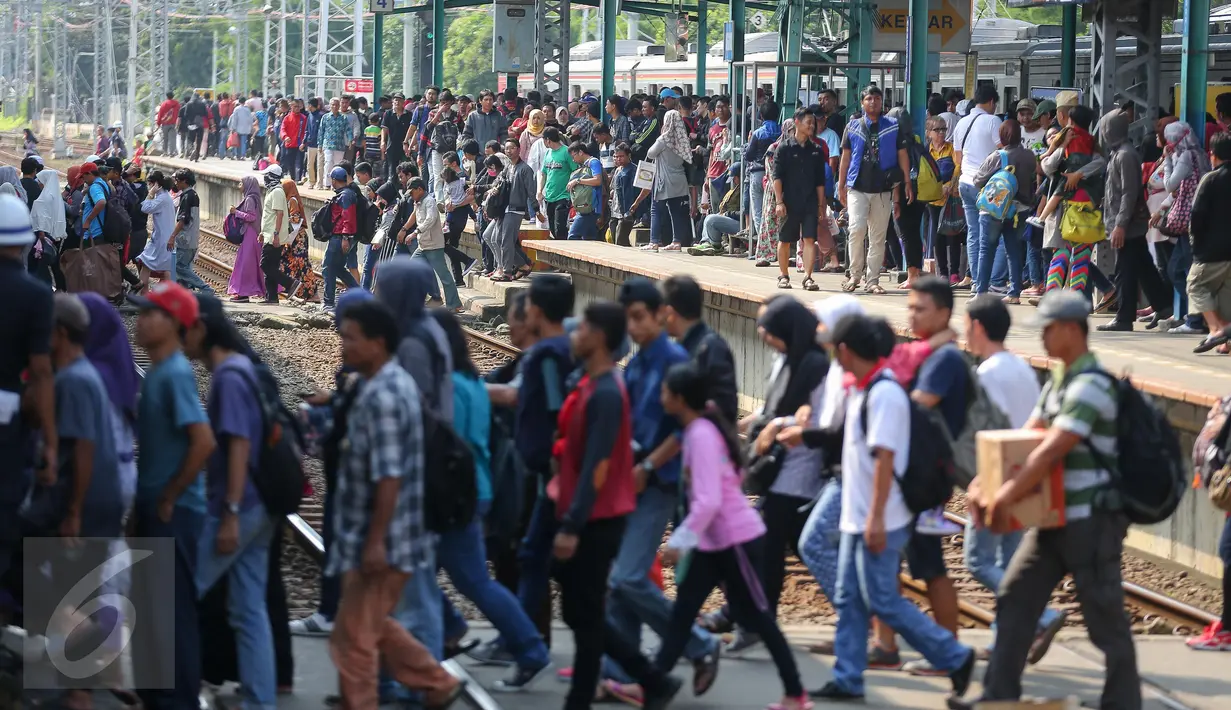 Sejumlah penumpang Comuter Line menyebrang antar peron di Stasiun Manggarai, Jakarta, Selasa (28/3). Stasiun Manggarai dipadati penumpang yang hendak berlibur pada Hari Raya Nyepi Tahun Baru Saka 1939. (Liputan6.com/Faizal Fanani)