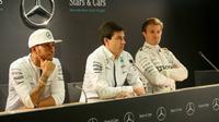 Bos Mercedes GP, Toto Wolff (tengah), mengaku tak segan untuk memecat Lewis Hamilton (kiri) atau Nico Rosberg jika persaingan keduanya memberikan pengaruh buruk bagi tim. (Crash)