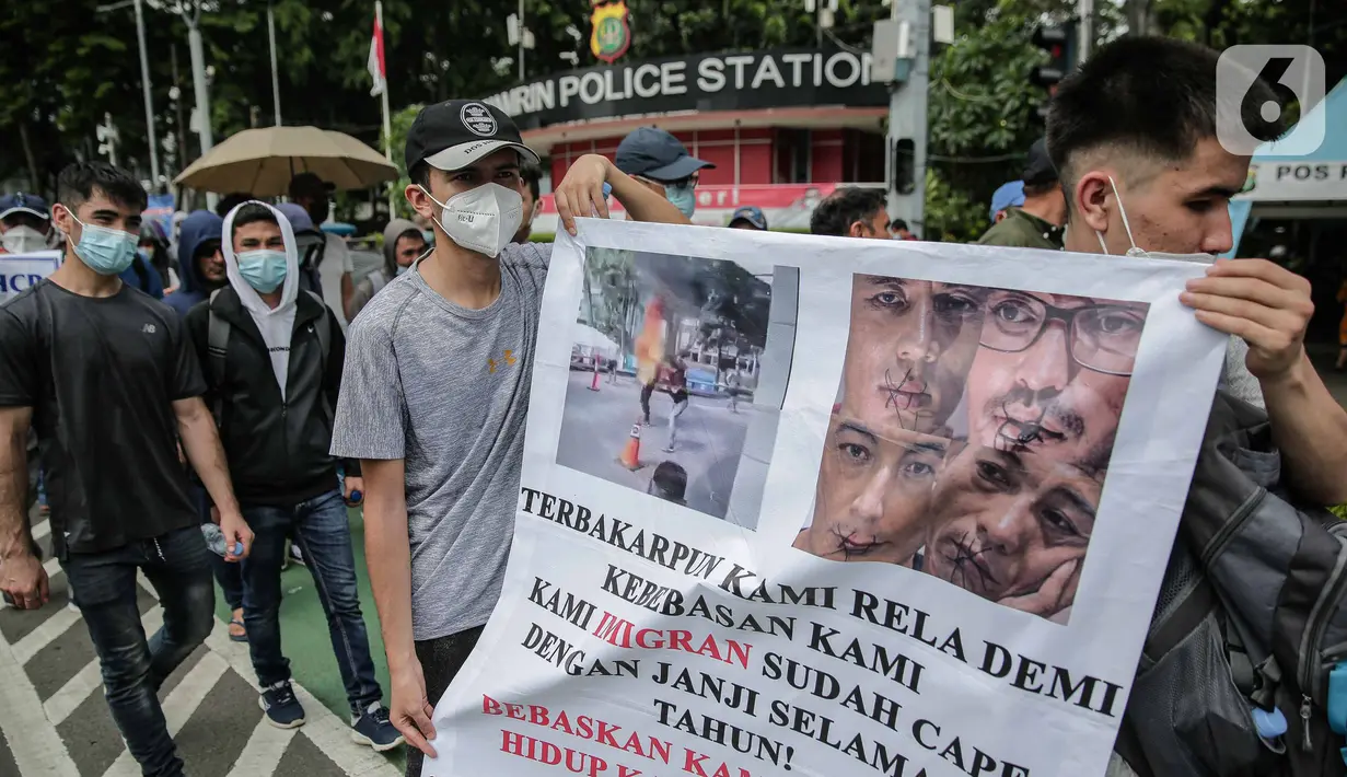 Ratusan imigran Afghanistan jalan kaki menuju Kedubes Kanada di Jakarta, Senin (13/12/2021). Dengan membawa spanduk dan poster, mereka menuntut UNHCR dan IOM segera memproses penempatan mereka ke negara tujuan seperti Kanada, Australia, Selandia Baru maupun AS. (Liputan6.com/Faizal Fanani)