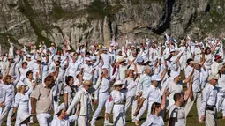 Anggota gerakan keagamaan internasional White Brotherhood menari di puncak Gunung Rila, Bulgaria, Senin (19/8/2019). Tarian tersebut ditampilkan dalam lingkaran konsentris yang mereka yakini dapat menghubungkannya dengan ritme kosmik dan melawan kesedihan. (NIKOLAY DOYCHINOV/AFP)